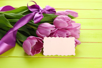 Beautiful bouquet of purple tulips on green wooden background