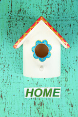 Decorative nesting box and sign on color background