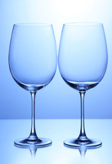 Empty wine glasses arranged on blue background
