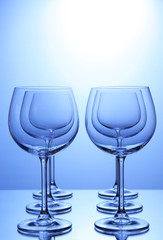 Empty wine glasses arranged on blue background