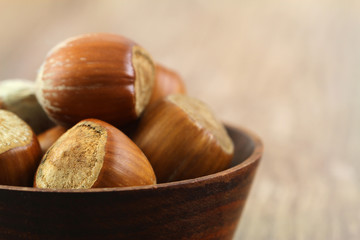 Hazelnuts in miniature wooden bowl, close up