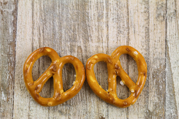 Two pretzel hearts on wooden background