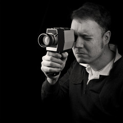 Fototapeta premium man filming with old classic 8mm cine film camera