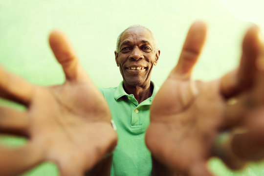 Old African Man With Hands And Arms Open, Embracing The Camera