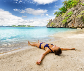 Fototapeta na wymiar Młoda kobieta jest relaks na piasku nad morzem