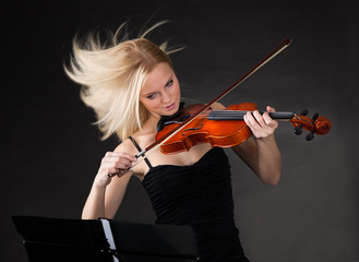 Young woman passionately playing violin