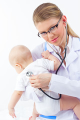 Attractive pediatrician listening cute baby heart by stethoscope
