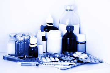 Medical bottles and pills in blue light