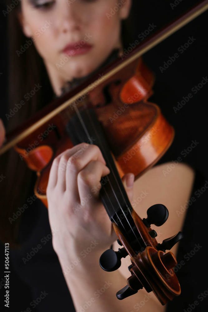 Wall mural Musician playing violin on black background