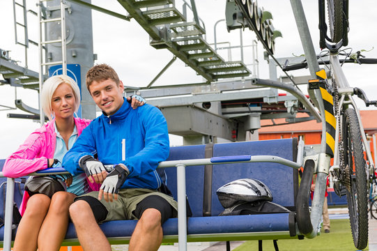 Young couple sitting chair lift waiting departing