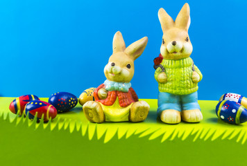Easter bunnies playing on grass on blue background