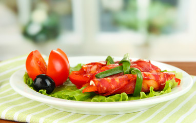 Salami rolls on white plate on bright background
