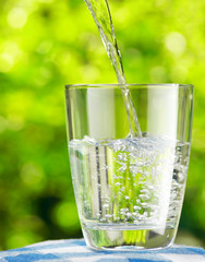 Glass of water on nature background