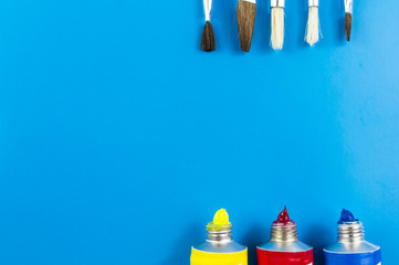 water colors and paint brushes on blue background