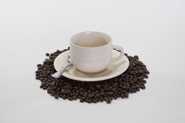 Coffee Beans Surround Coffee Cup on Isolated White Background