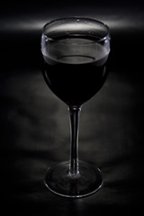 Glass of Wine Spotlighted on Reflective Black Background