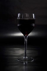 Glass of Wine Spotlighted on Reflective Black Background