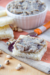 Fresh pate of white haricot in ceramic cup and on toast