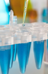 Detail of a laboratory pipette depositing a drop