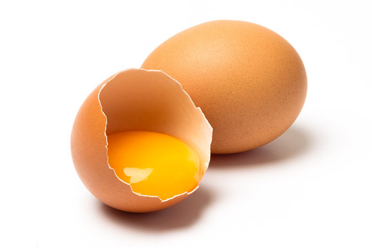 Two eggs, one broken, with shadow isolated on white background