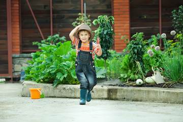 Fototapeta na wymiar Portret chłopca pracy w ogrodzie w wakacje