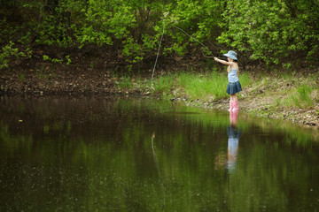 Fototapeta na wymiar Dziewczynka prowadzą połowy na jeziorze w lesie