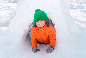 child playing in snow castle