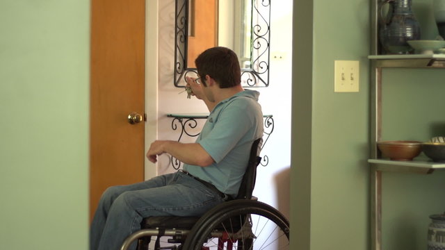 Man in a wheelchair entering his home
