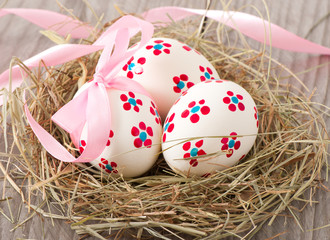 easter eggs in nest on wooden table