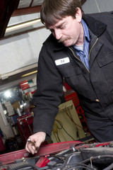 Fototapeta na wymiar Automotive Technician Works Under the Car Hood in Auto Repair