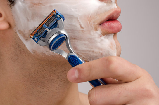 Close Up On A Man Shaving His Beard In The Morning With A Razor.