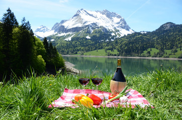 Wine and vegetables served at a picnic in Alpine meadow. Switzer