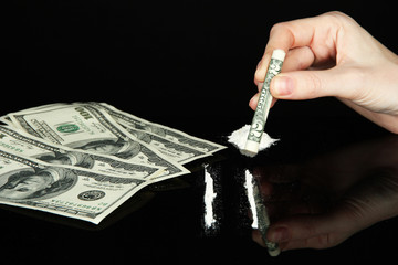Cocaine drugs lines and female hand holding rolled dollar