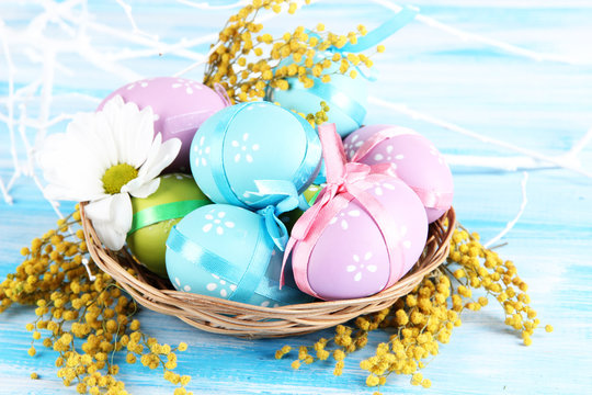 Easter eggs in basket and mimosa flowers,