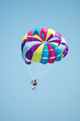 Multi coloured parachute over the blue sky