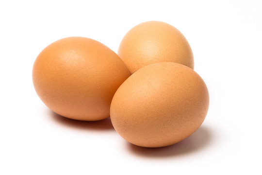 Three brown eggs with shadow isolated on a white background