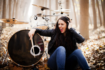 Woman playing drums in the forest