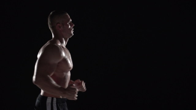 Muscular man running in profile, medium shot left