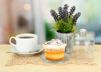 Cupcake on saucer with glass cover, on bright background