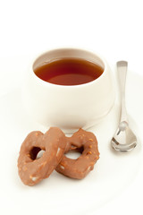 Two cookies in shape of heart, cup with tea and tea spoon