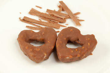 Cookies shaped as heart and sticks of cinnamon on plate