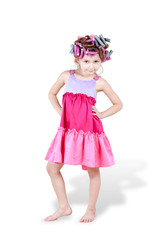 Little girl with  hair-curlers in her hair poses with her hands