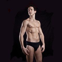 Naklejka premium Handsome muscular guy on black background