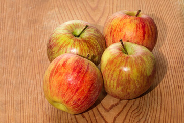 Quattro mele su tavolo in legno