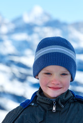 Happy boy portrait on winter  mountain background.