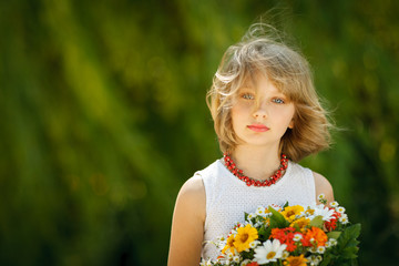 Girl with bunch of flowers standing outdoors