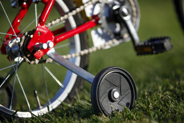 Dettaglio di bici rossa con rotelle.