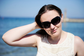 Pretty woman wearing sunglasses at the beach