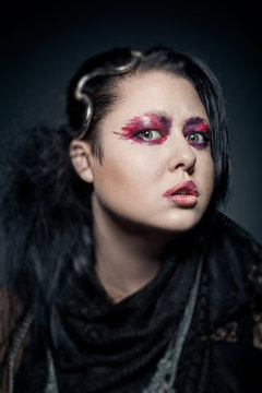 portrait of young brunette woman with fashion makeup on dark