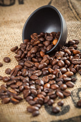 Spilled coffee beans and black cup
